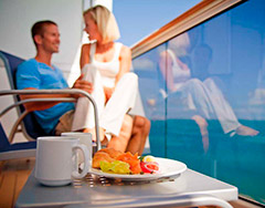couple on cruise ship balcony with fruit plate